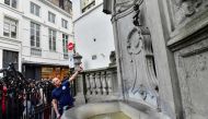 Brussels' energy technician Regis Callens points at the Manneken-pis landmark statue in Brussels on April 2, 2019.  AFP/Emmanuel Dunand 
 