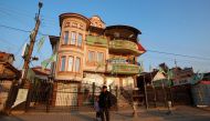A man walks next to a house decorated with party flags in Suto Orizari, a district with Europes largest Roma communities, Macedonia, December 7, 2016. Thomson Reuters Foundation/Ognen Teofilovski