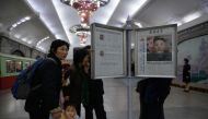 Commuters look at a copy of the Rodong Sinmun newspaper showing an image of North Korea's leader Kim Jong Un, at a newstand in a subway station in Pyongyang on April 13, 2019. AFP / Ed JONES
