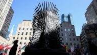FILE PHOTO: People walk past a large replica of the iron throne before the premiere of the final season of 