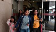 Baby Jane Allas (C), a 38-year-old mother of five Filipina domestic worker who was sacked after she was diagnosed with cervical cancer leaves with family members and supporters after a hearing at the Labour Tribunal in Hong Kong on April 15, 2019, which o