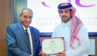 Ali Derbala (left) receives a certificate from Salem Al Mannai, Deputy Group President & CEO of QIC Group, at the award ceremony held at QIC headquarters in West Bay. 