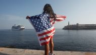 A woman with a US flags looks at the arrival of US Carnival cruise ship Adonia at the Havana bay, May 2, 2016. Reuters