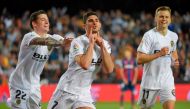 Valencia midfielder Goncalo Guedes (centre) celebrates with team-mates Santi Mina (left) and  Denis Cheryshev after scoring during the Spanish league football match against Levante UD at the Mestalla Stadium in Valencia on April 14.