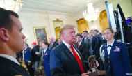 US President Donald Trump departs with a statuette after speaking at an event honoring the Wounded Warrior Project Soldier Ride in the East Room of the White House in Washington, DC on April 18, 2019. AFP / Mandel Ngan

