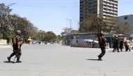 Afghan security personnel stand guard near the Afghan communication ministry as an attack between Afghan forces and attackers is still going on in central Kabul on April 20, 2019.   AFP / STR