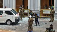 Sri Lankan security personnel stand next to an ambulance outside St. Anthony's Shrine in Kochchikade in Colombo on April 21, 2019 following a blast at the church. / AFP / ISHARA S. KODIKARA 