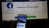 An illustration photo shows the Facebook page displayed on a mobile phone held in front of a computer screen at a cyber-cafe in downtown Nairobi, Kenya April 18, 2019. Reuters/Stringer