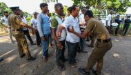 People pass from a checkpoint to attend funeral ceremony at Madampitiya cemetery for the victims of multiple terror attacks in Colombo, Sri Lanka on April 24, 2019. Chamila Karunarathne - Anadolu 
