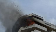 Flames and debris fly out from a burning 23-storey residential building in Paranaque City in suburban Manila on April 29, 2019. According to local media reports, six people were injured in the incident, with no deaths reported so far. / AFP / Ted Aljibe 