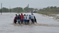 Residents push a car through the floods in Mazive, southern Mozambique, on April 28, 2019. AFP / Emidio Josine
