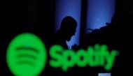 FILE PHOTO: A trader is reflected in a computer screen displaying the Spotify brand before the company begins selling as a direct listing on the floor of the New York Stock Exchange in New York, U.S., April 3, 2018. REUTERS/Lucas Jackson/File Photo