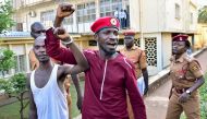 Opposition figurehead Hon Kagulanyi Robert aka Bobi Wine walks handcuffed together with another prisoner before boarding the prison bus leading him to Luzira maximum prison in Kampala on April 29, 2019.  AFP / Nicholas Bamulanzeki
 