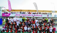Vinales (third row centre), poses for a picture with children, who are part of the Qatar Motorsports Academy, at the Losail International Circuit.