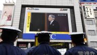 Japanese policemen stand guard as they look at a screen displaying live news of Japanese Emperor Akihito's abdication ceremony in Tokyo on April 30, 2019. AFP / Toshifumi KITAMURA
