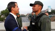 Venezuelan opposition leader Juan Guaido, who many nations have recognised as the country's rightful interim ruler, shakes hands with a military member near the Generalisimo Francisco de Miranda Airbase 