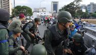 Members of the Bolivarian National Guard loyal to Venezuelan opposition leader and self-proclaimed acting president Juan Guaido take position in front of La Carlota base in Caracas on April 29, 2019. AFP / Yuri CORTEZ