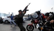 Soldiers and people react to the sound of gunfire near the Generalisimo Francisco de Miranda Airbase 