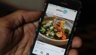 Vikas Garg, founder of abillionveg, shows a mobile phone app that reviews vegetarian and vegan dishes, demonstrating how to use it in Singapore on Feb 12, 2019. Thomson Reuters Foundation/Thin Lei Win 
