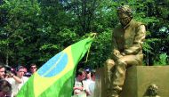 This April 25, 1997 file photo shows fans carrying a Brazilian flag gather to see the unveiling of a statue of former Brazilian Formula One driver Ayrton Senna, at the spot on the Imola racetrack where Senna was killed on May 1, 1994 during the San Marino