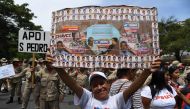 Supporters of Venezuelan President Nicolas Maduro display placard with pictures of Maduro and late leader Hugo Chavez during a rally on May Day in Caracas on May 1, 2019.   AFP / Yuri CORTEZ