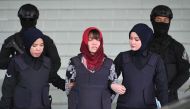 In this file photo taken on March 14, 2019, Vietnamese national Doan Thi Huong (C), accused of murdering Kim Jong Nam, the half brother of North Korean leader Kim Jong Un, leaves Shah Alam High Court escorted by police, outside Kuala Lumpur.  / AFP / MOHD