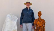 Renowned British artist Antony Gormley poses next to his sculpture called 