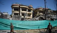 Afghan security forces stand at the site of an attack by Taliban militants, a day after the assault on a compound housing an international aid organisation, in Kabul on May 9, 2019.  AFP / WAKIL KOHSAR