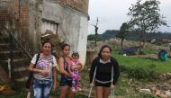 Landslide survivor Eugenia Torres and her friends stand behind a home in a flood prone area in Mocoa, Colombia, March 28, 2019. Thomson Reuters Foundation / Anastasia Moloney