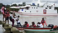 Locals get on a boat to the hospital ship 