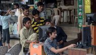 In this file photo taken on May 9, 2014 Pakistani vendors use computers to upload music and video files onto their client's mobile phones at a market in Faisalabad. AFP / Farooq Naeem