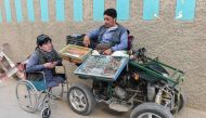 A Pakistani disabled vendor (R) belonging to the Shiite Hazara minority Muslim community waits for customers at a roadside in Hazara town, a neighbourhood in Quetta, on May 3, 2019. AFP / Banaras Khan