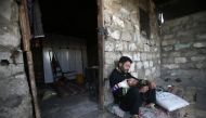 :A Palestinian man with his child on May 13, 2019 in the southern Gaza Strip refugee camp of Khan Yunis. (AFP / MOHAMMED ABED)