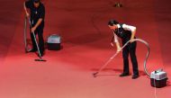 Employees vaccum the red carpet after guests and film cast and crews arrived for the screening of the film 