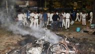 In this photo taken on May 14, 2019 Indian police stand next to burning debris on a street following clashes by rival groups during a campaign rally event held by Amit Shah, president of the ruling Bharatiya Janata Party (BJP), in Kolkata. (AFP)