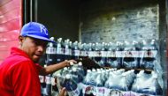 A man unloads bottles of Coca Cola from a truck in Caracas on May 27, 2016. AFP/Ronaldo Schemidt