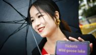 A festival goer holds up her mobile phone asking for invitations for the screening of the film 
