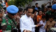 Indonesian President Joko Widodo (C) and his running mate Ma'ruf Amin (center R) speak with residents in a neighbourhood in Jakarta on May 21, 2019.  AFP / Goh Chai Hin
 