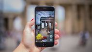REPRESENTATIVE IMAGE: A woman points her smart phone at the Brandenburg Gate as she plays the Pokemon Go mobile game in Berlin on July 13, 2016. AFP