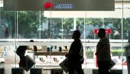 People walk past a Huawei retail store in Beijing on May 23, 2019.  AFP / FRED DUFOUR