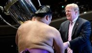 US President Donald Trump presents the President's Cup to sumo wrestler Asanoyama during the Summer Grand Sumo Tournament at Ryogoku Kokugikan Stadium in Tokyo on May 26, 2019. / AFP / Brendan Smialowski