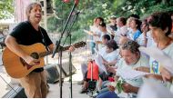 Brazilian musician Ricardo ‘Rico’ Branco de Vasconcelos (L), leads the ‘With One Voice’ choir performance during the Good Actions Day Fair organized by the NGO Atados at Garota de Ipanema Park in Rio de Janeiro on April 4, 2019. AFP