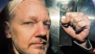 In this file photo taken on May 01, 2019 WikiLeaks founder Julian Assange gestures from the window of a prison van as he is driven out of Southwark Crown Court in London, after having been sentenced to 50 weeks in prison for breaching his bail conditions 