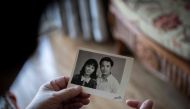 In this picture taken on April 10, 2019, You Weijie, 66, looks at a photograph of her and husband Yang Minghu, in Beijing.  AFP / Nicolas Asfouri