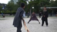 In this photo taken on May 19, 2019, Afghan children play cricket in a field in Kabul.   AFP / Wakil Kohsar