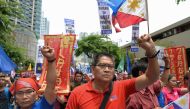 Activists and progressive legislators raise clinched fists during a protest in front of the Chinese consulate in Manila on June 12, 2019, against the Asian superpower's growing sway in the Philippines and as tensions rise over Beijing's presence in the di
