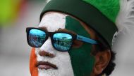 An Indian supporter poses with his face painted in the national colours as play is delayed in the 2019 Cricket World Cup group stage match between India and New Zealand at Trent Bridge in Nottingham, central England, on June 13, 2019.  AFP / Dibyangshu Sa