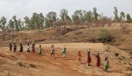 Women carry pitchers filled with water from an opening made to filter water next to a polluted lake in Thane, India June 13, 2019. REUTERS/Prashant Waydande