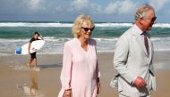 A surfer walks past as Prince Charles and Camilla, Duchess of Cornwall, visit Broadbeach, Australia, April 5, 2018. Reuters/Phil Noble