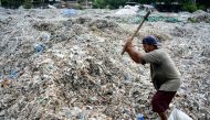 In this picture taken on December 11, 2018 a man searches for plastic waste for resale at a dump in Mojokerto, East Java province. Around 300 million tonnes of plastic are produced every year and end up in landfill or the seas, according to the Worldwide 